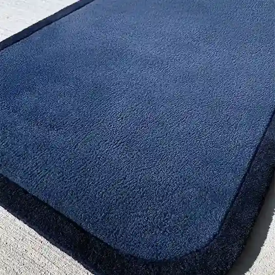 minimalist navy rug styled with wood furniture