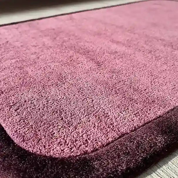 minimalist pink rug styled with wood furniture