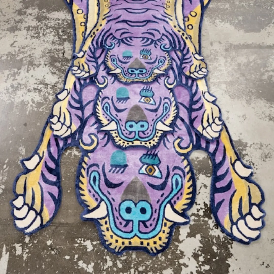 Close-up of Tibetan tiger pattern with bold lines and colorful accents on purple wool rug