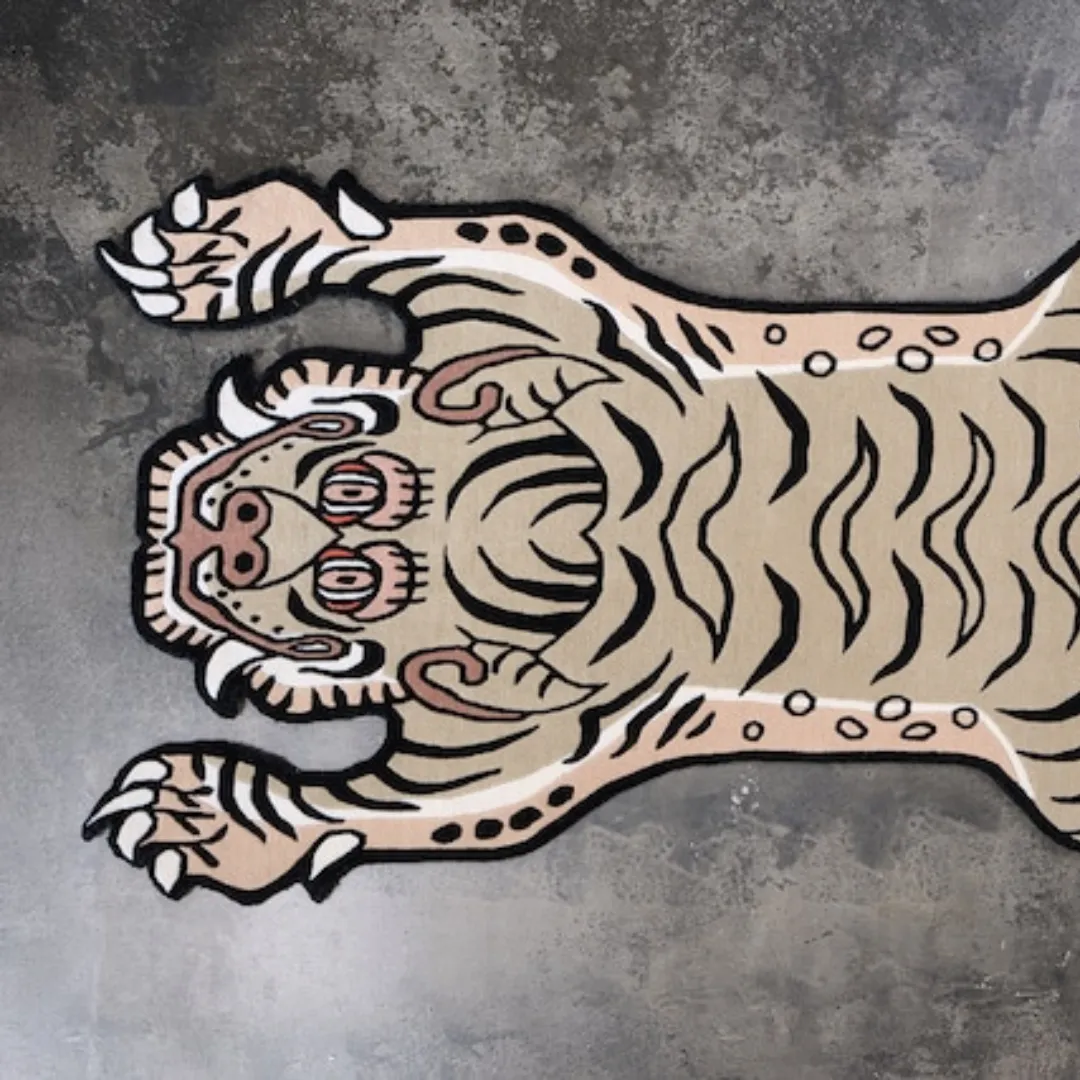 Artisan-crafted tiger rug with cream background, cartoon-style face, and traditional Tibetan pattern.