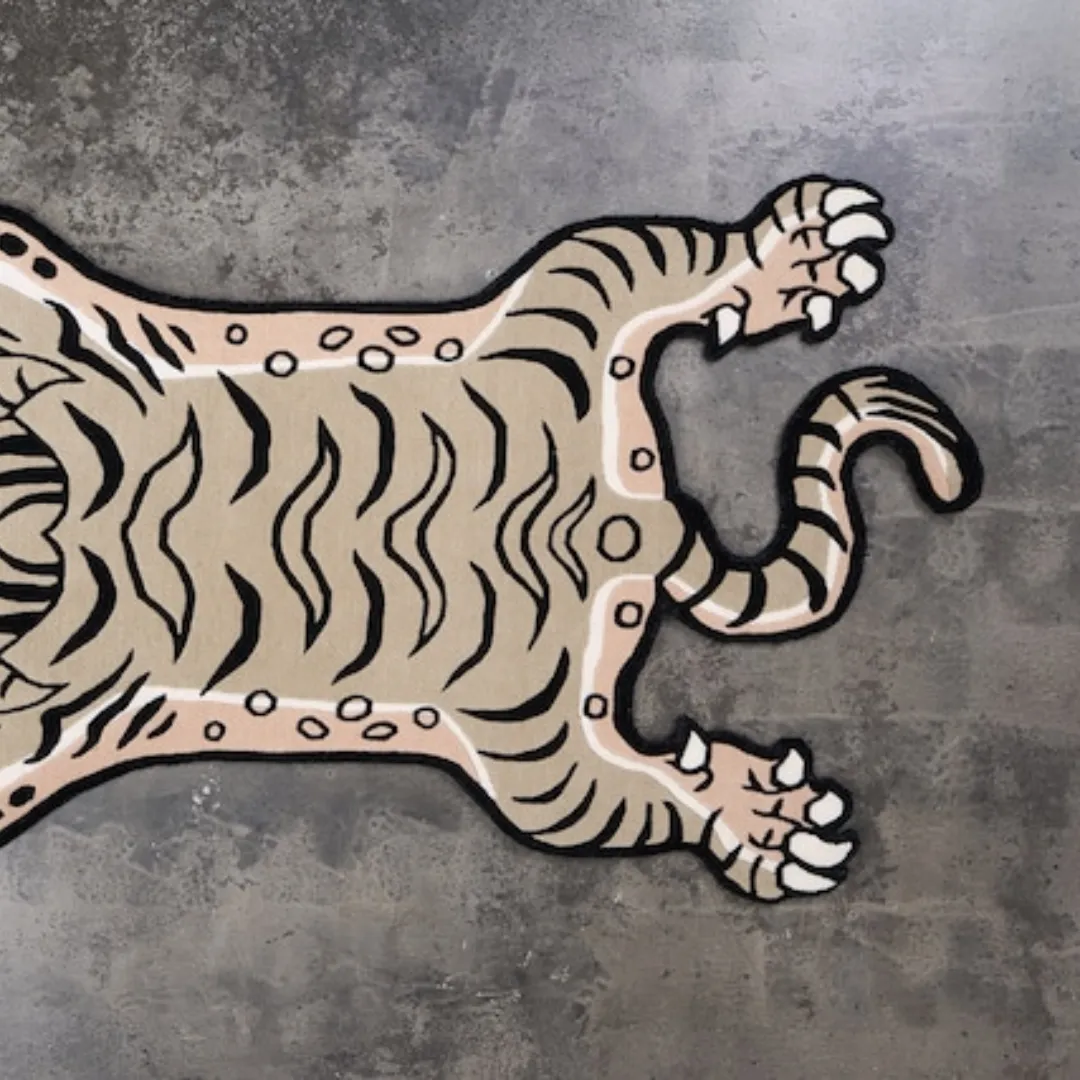 Hand tufted Tibetan tiger rug in cream color featuring playful stripes and bold facial details.