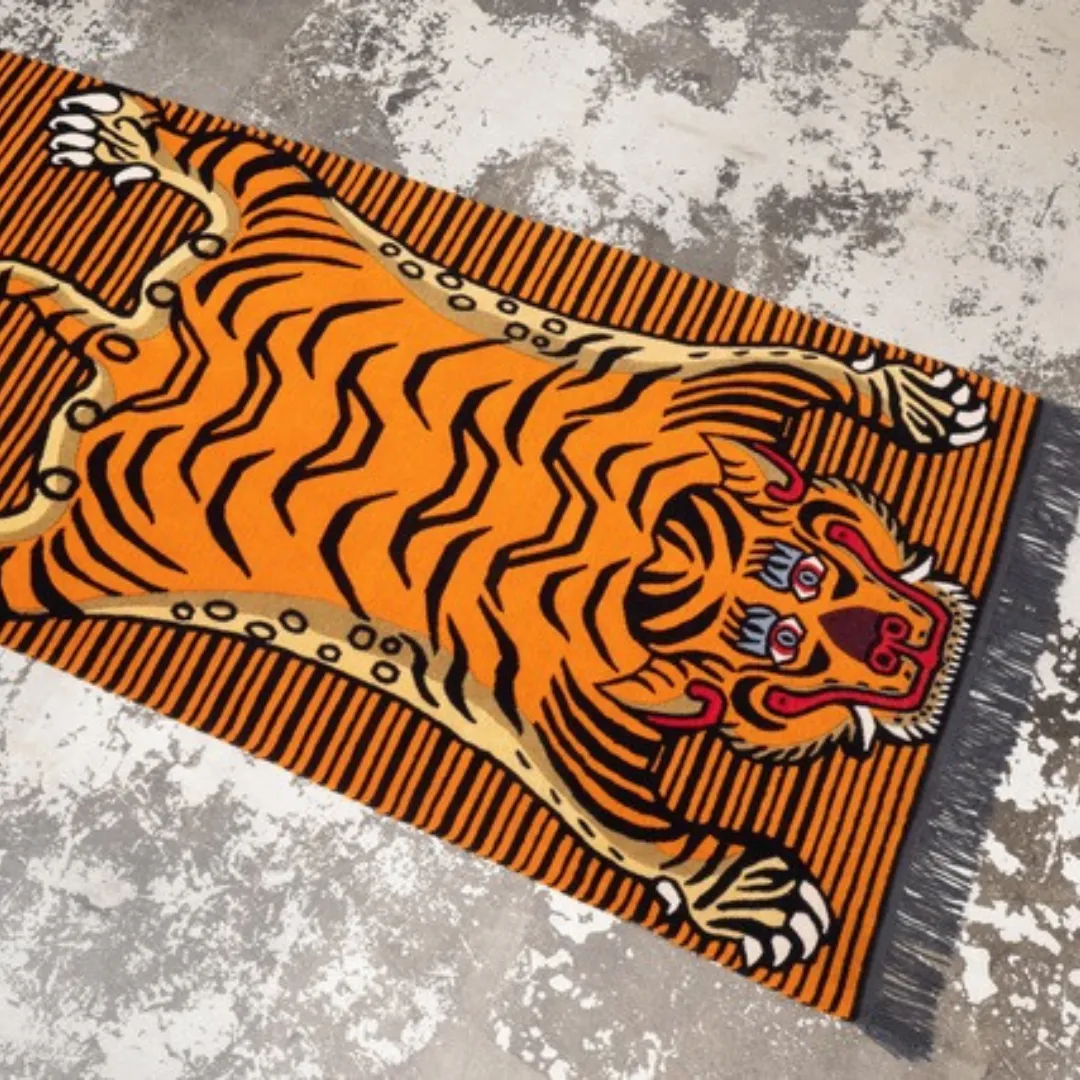 Hand-tufted orange Tibetan tiger rug with bold black stripes and detailed facial pattern