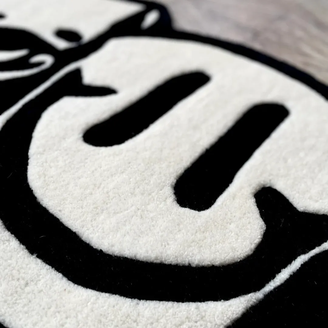 Twin Reaper Inked Rug Bold monochrome Twin Reaper Rug with skull, smiley, and statue face art – hand-tufted modern rug