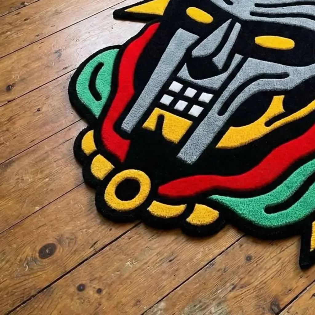 Graffiti Deity Rug Mask Design Close Up Texture Close up angled shot of the Graffiti Deity rug showing the dense black and grey wool tufting and hand carved details.