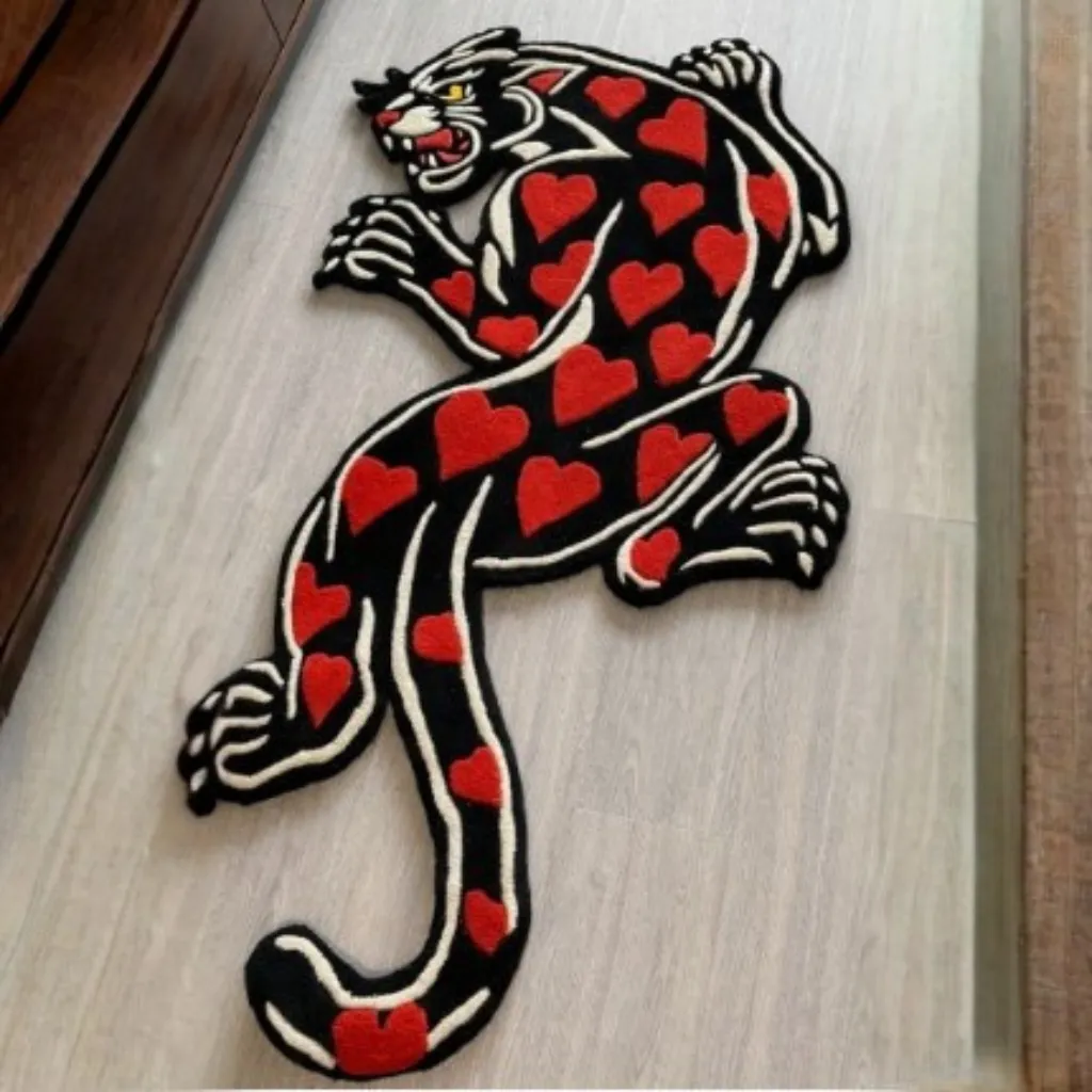 amour panther red panther skin shaped rug wood floor Close-up top down view of the Amour Panther Inked Rug, focusing on the fierce panther face designed in a traditional tattoo style with bold black "inked" outlines and romantic pink shading.