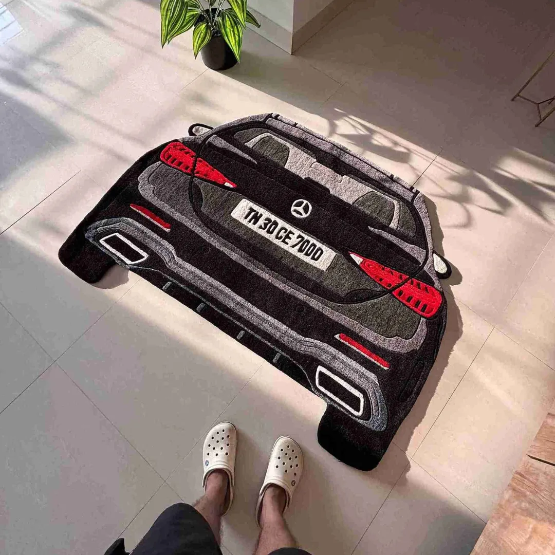 grand crest mercedes suv rug Top down view of the Grand Crest rug featuring a custom die-cut design of a Mercedes-Benz luxury car rear in dark grey and black hand-tufted wool.
