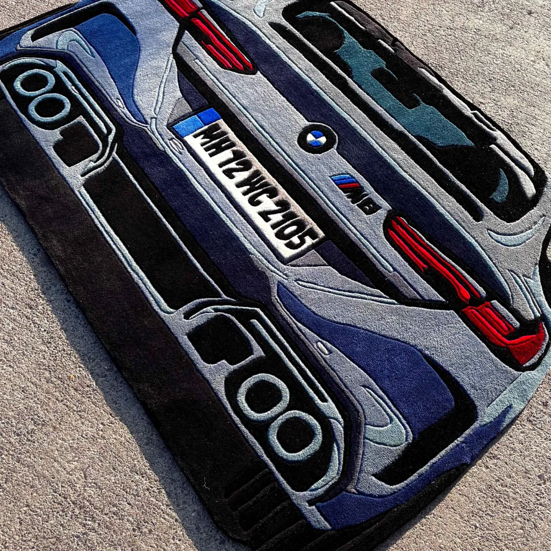 iron nomad rug automotive floor decor Angled perspective view of the Iron Nomad rug on concrete, showcasing the realistic "Iron Grey" color palette and dynamic shape perfect for a garage or car enthusiast's room.