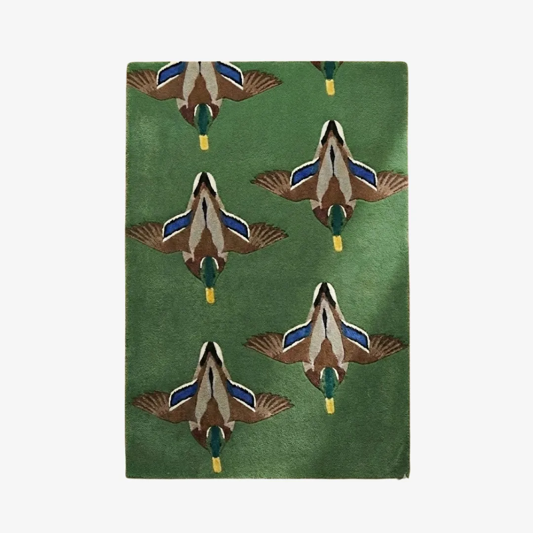 verdant flight flying ducks wool rug Top down view of the Verdant Flight rug showcasing the consistent pattern of mallards in flight against a deep verdant green backdrop.