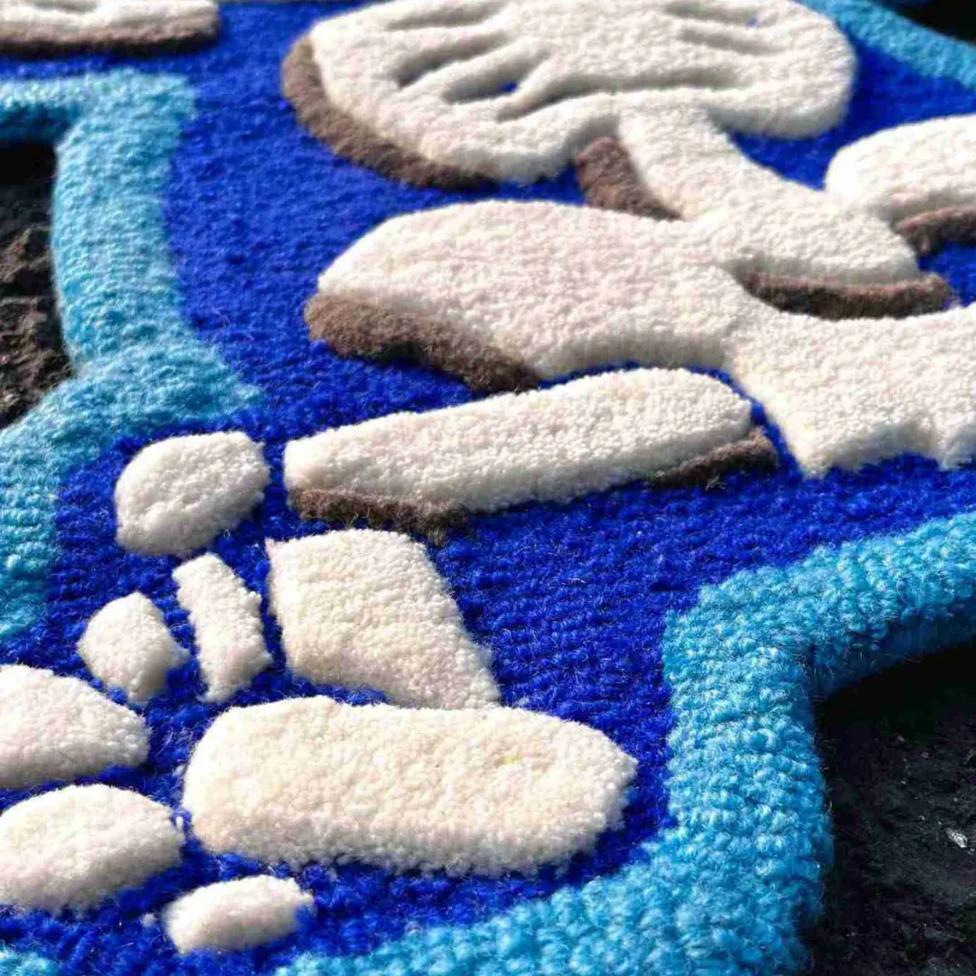 Close-up texture detail of the Azure Flux rug, highlighting the plush hand-tufted wool and the deeply carved 3D effect that separates the white skeletal face and teeth from the dark and light blue background.