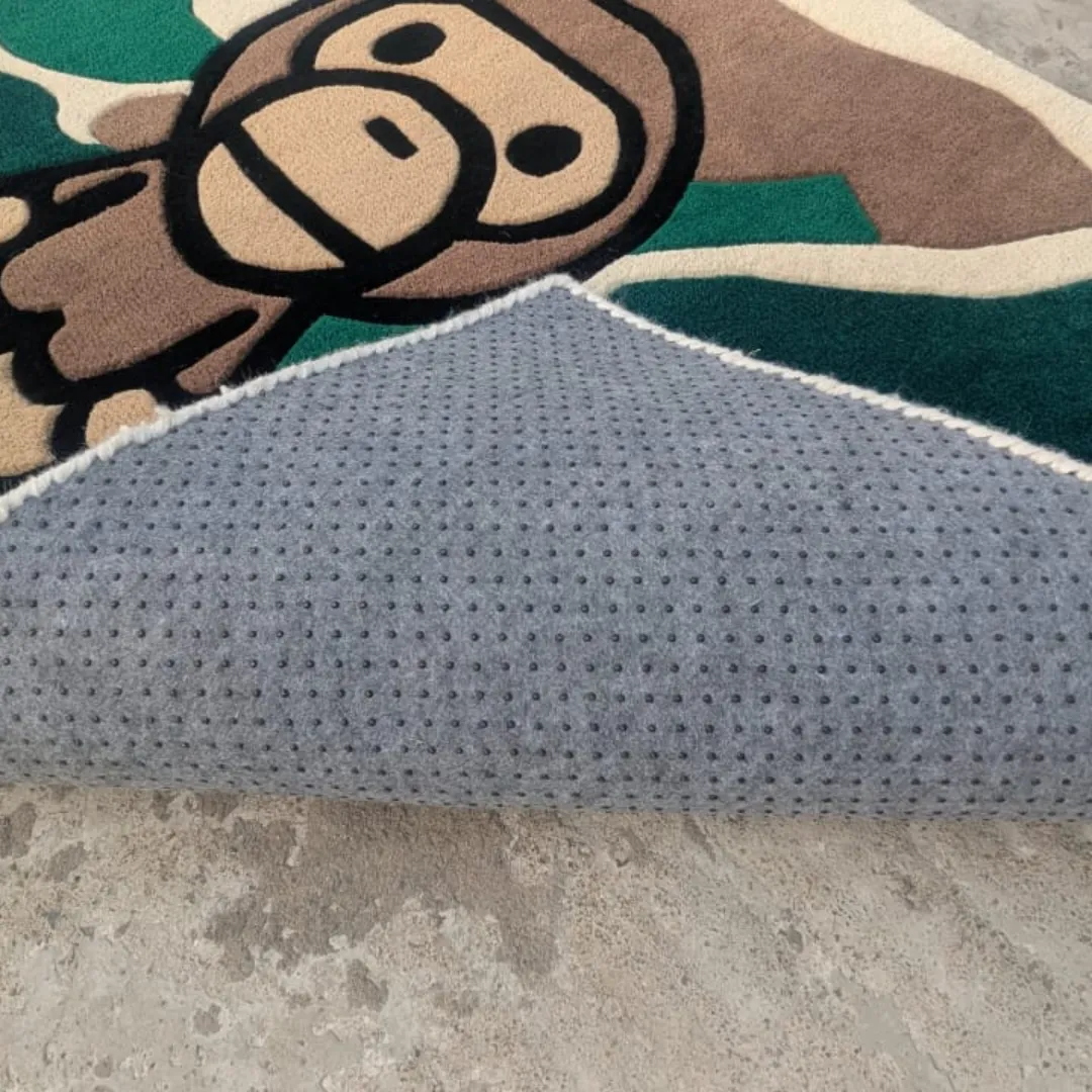 Angled view of the Camo Heritage rug with a corner folded over, revealing the grey non-slip dotted backing underneath the thick, tufted wool pile of the ape face design.