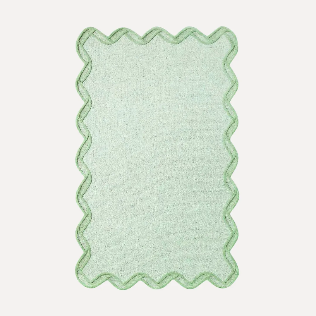 Green scallop edge rug with darker green border and soft curves