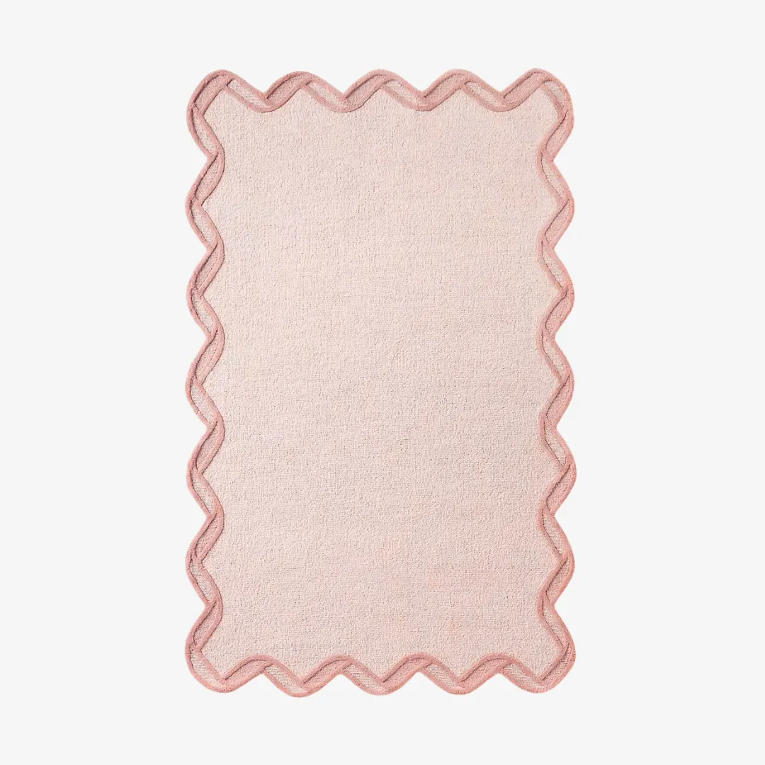 Pink scallop edge hand tufted rug with soft wavy border on light floor