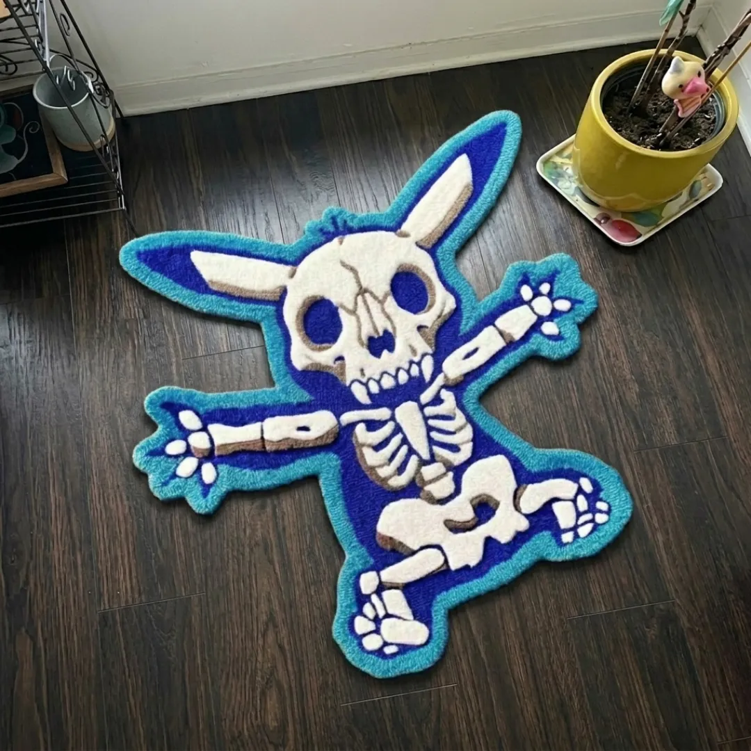 azure flux rug top view Azure Flux skeleton creature shaped tufted area rug featuring vibrant blue tones and white bone details, displayed flat on a dark wooden floor.