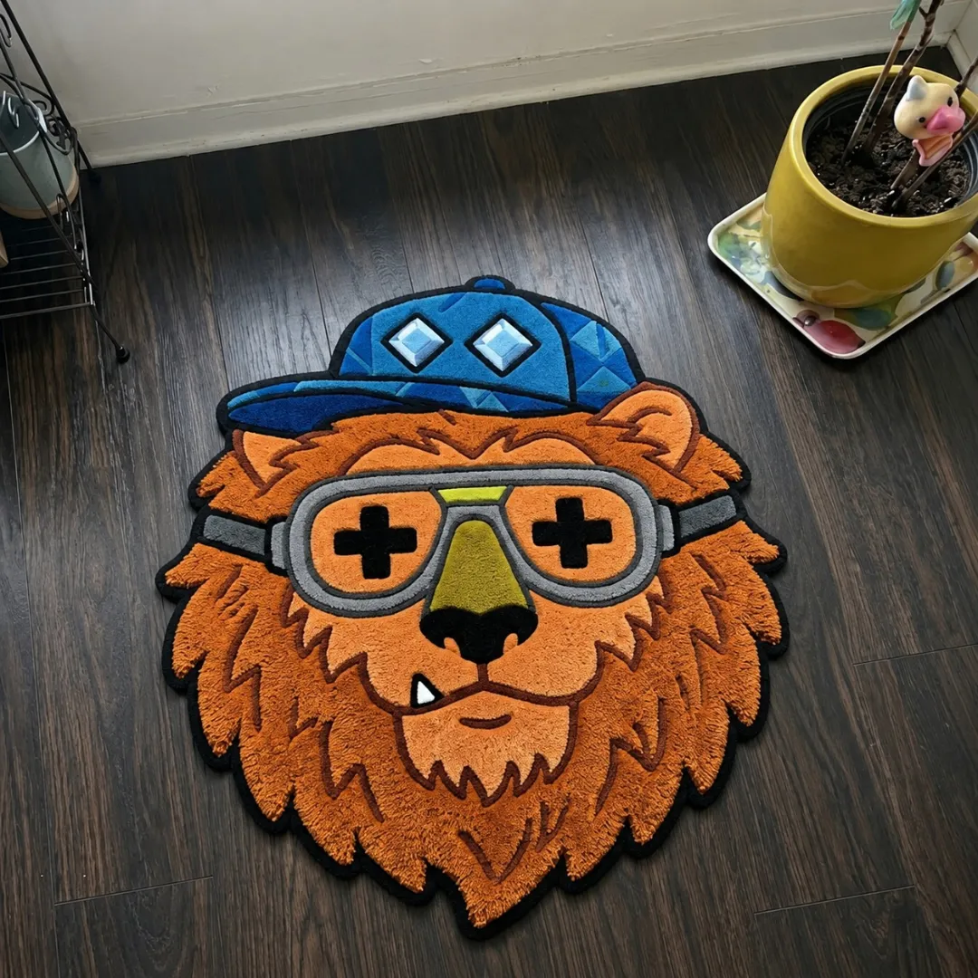 swag snout rug top view Swag Snout lion character shaped tufted area rug displayed flat on a dark wooden floor.
