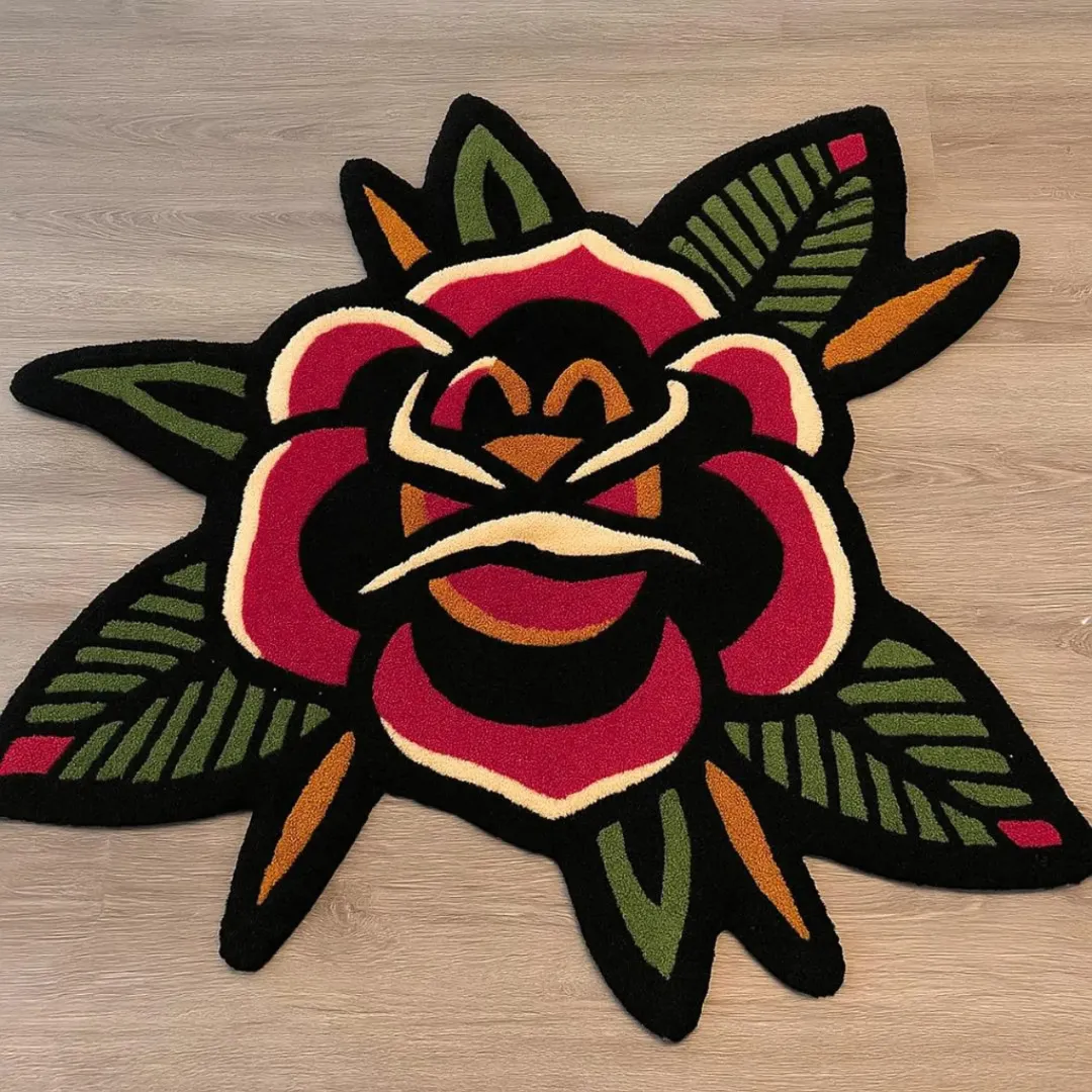 Bold rose tattoo rug with bright red petals and green leaves.
