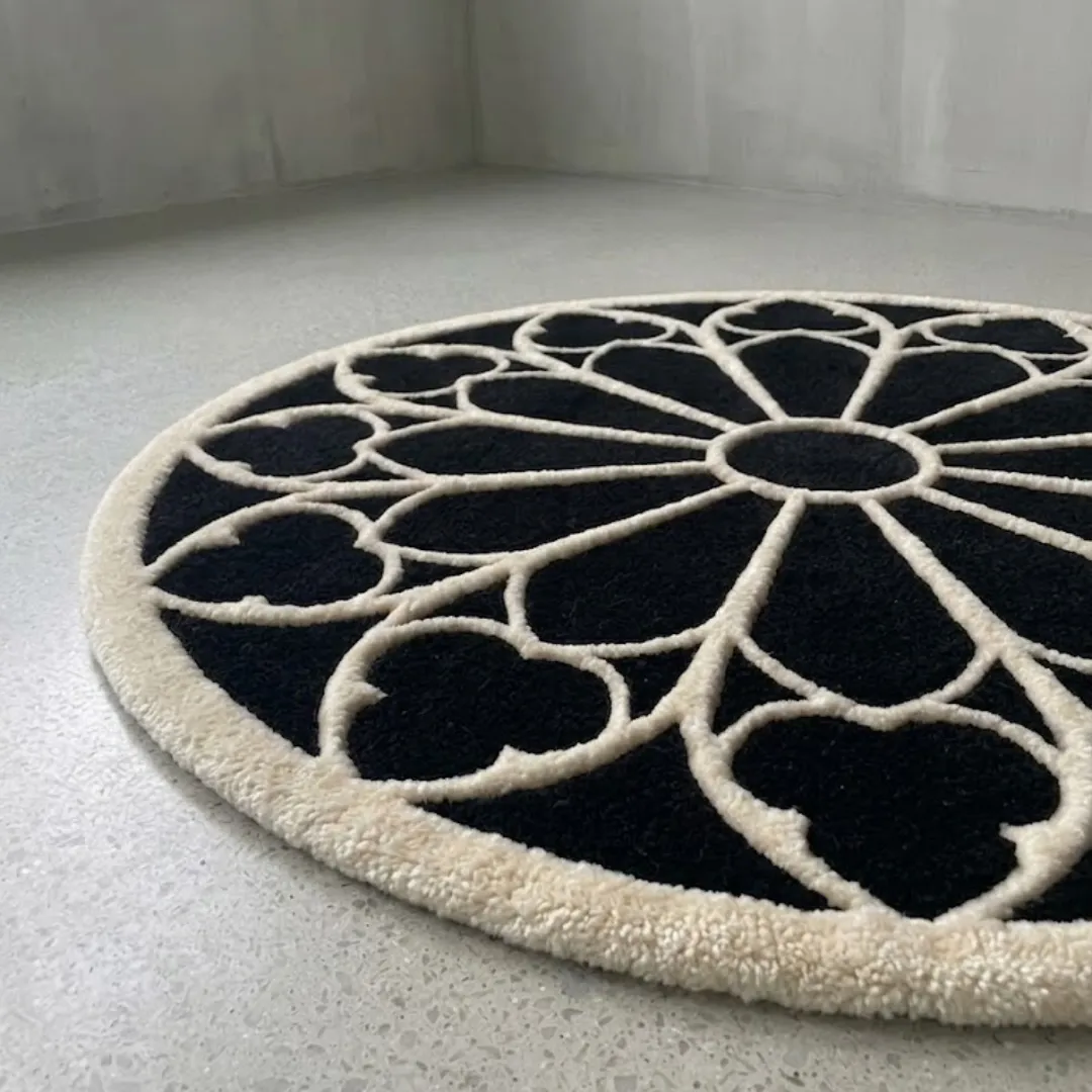 eclipse halo rug angled close up An angled close-up view of the round Eclipse Halo Rug on a smooth light floor. The image highlights the plush, high-quality tufted texture of the contrasting black and white yarn, showcasing the detailed geometric halo design.