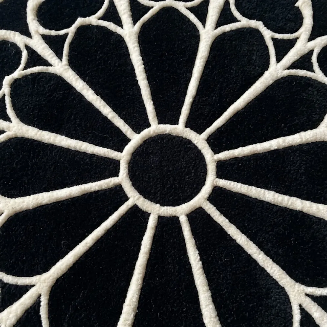 eclipse halo rug center detail A detailed close-up of the center of the Eclipse Halo Rug. The image focuses on the thick, tufted white lines radiating symmetrically from a central black circle, emphasizing the crisp craftsmanship of the geometric pattern.