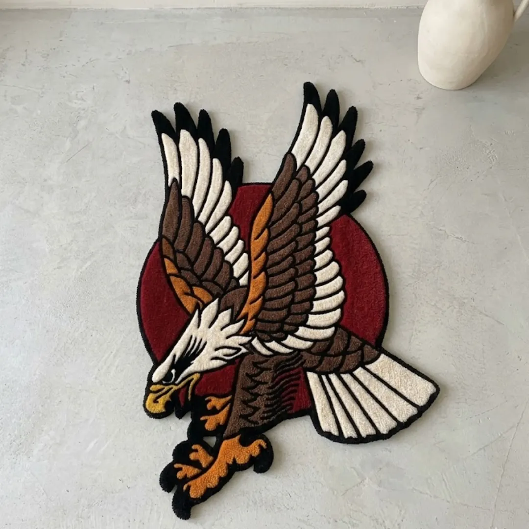 american eagle traditional rug full view Full view of a tufted American eagle traditional rug featuring a diving brown and white eagle against a red circle background on a light floor next to a white vase.