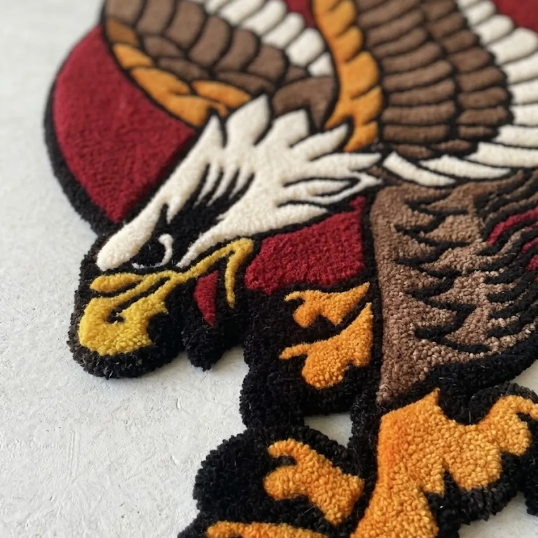 american eagle traditional rug texture close up Close up angled view of an American eagle traditional rug highlighting the textured yarn details of the white feathered head, yellow beak, and orange talons.