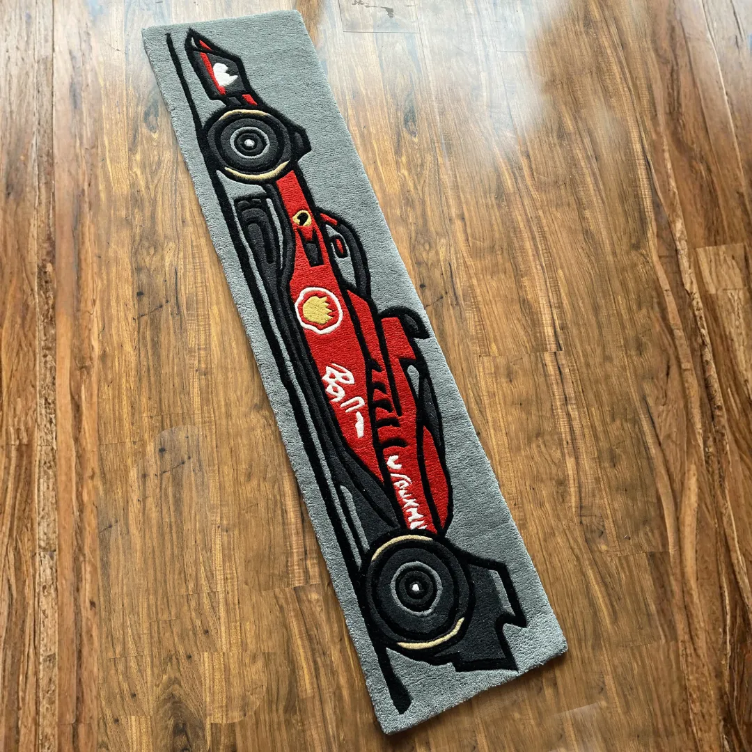 asphalt aura formula 1 runner rug Top down view of the Asphalt Aura runner rug featuring a stylized red Formula 1 race car illustration on a grey asphalt-colored background.