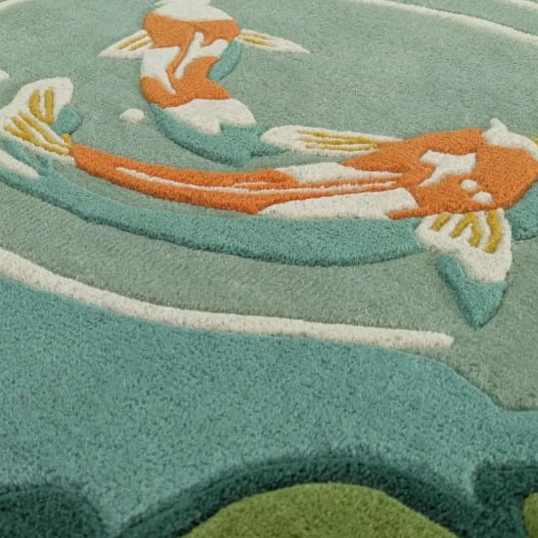 mizu garden rug koi fish texture Close-up detail of the Mizu Garden rug showing the intricate hand-tufted texture of the orange koi fish and the precise carving of the water ripples in soft wool.