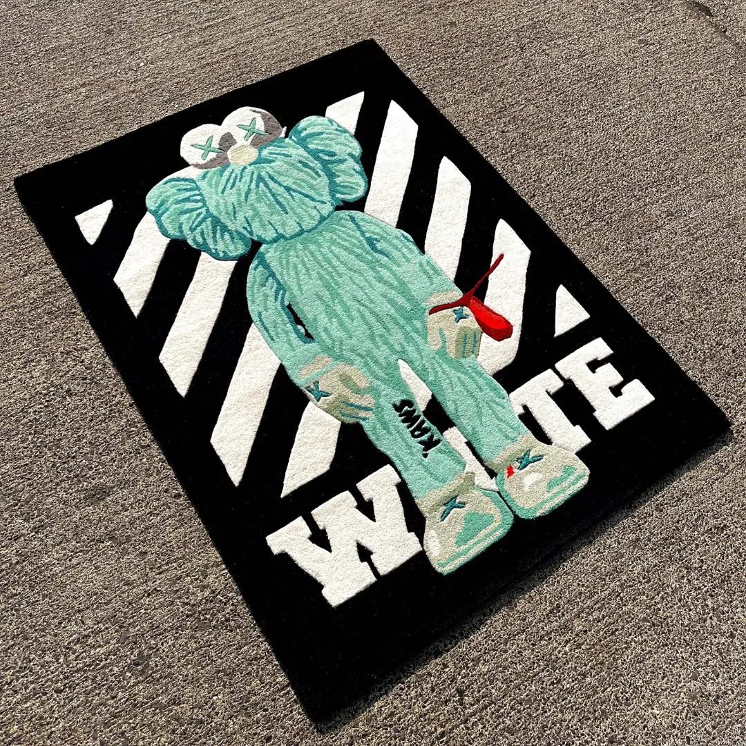virx column rug angle Angled view of the Virx Column rug placed on a concrete surface, showcasing the striking pop-art design of a mint green character holding a red balloon over a contrasting black and white striped background.