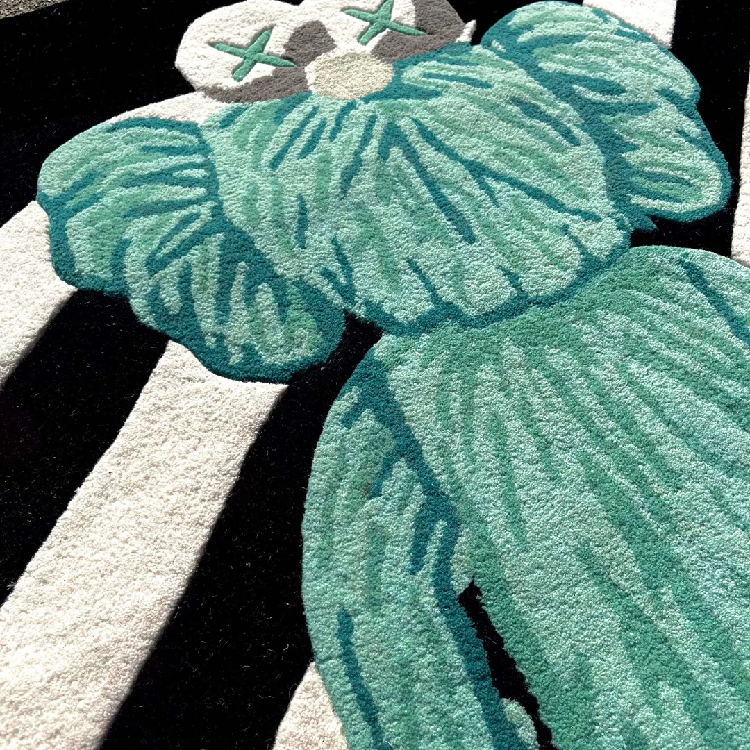 virx column rug head detail Close-up detail of the Virx Column rug, highlighting the dense, plush hand-tufted wool texture of the mint green character's face with its signature grey X-eyes against the black and white stripes.