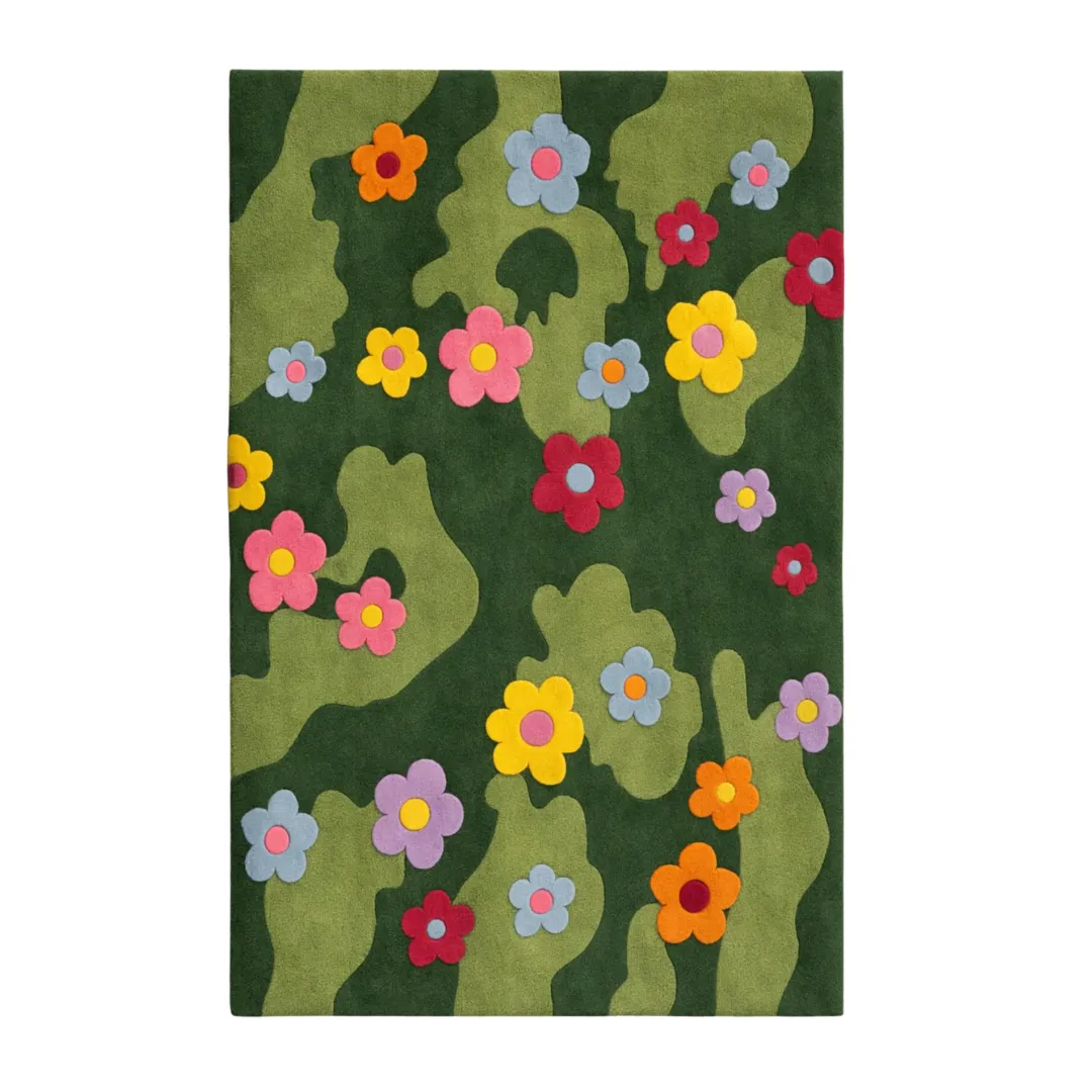 daisy meadow rug top down view A flat, overhead shot of the Daisy Meadow Rug. The design showcases a hand-tufted abstract pattern of light and dark green waves, decorated with colorful pink, yellow, blue, red, orange, and purple daisies.