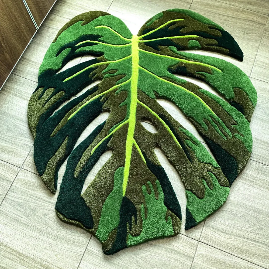 monstera flux rug full overhead view Full overhead view of the Monstera Flux Rug laying completely flat on a light tiled floor, showcasing its intricate cut-out edges and rich green tufted shading.