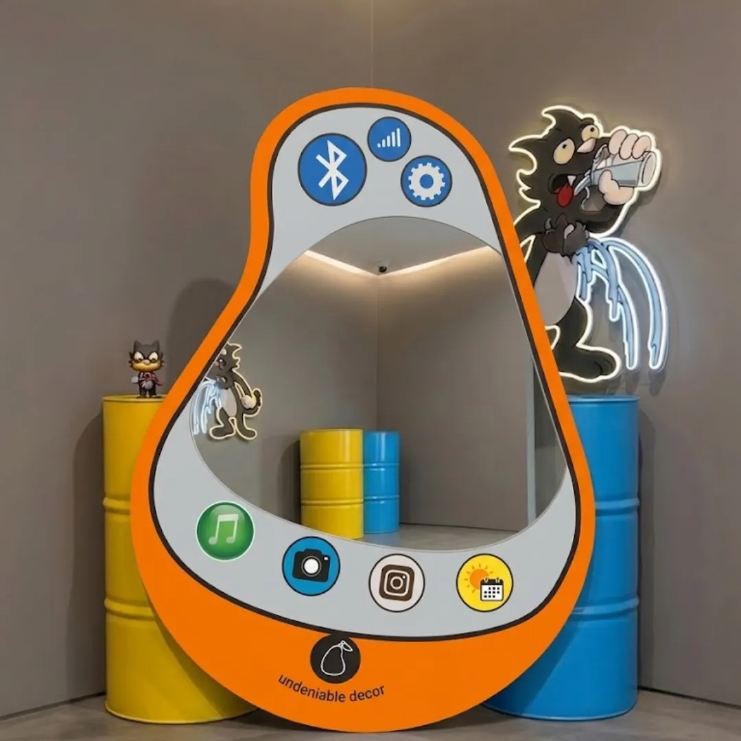 pear pop phone Interior styling view of the Pear Pop Phone Mirror displayed in a creative pop art studio space flanked by bright yellow and blue industrial barrels and glowing neon cartoon wall decor.