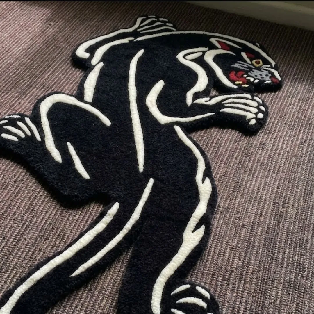 shadow prowl panther shaped area rug interior lifestyle An interior lifestyle shot of the Shadow Prowl panther-shaped rug placed in a cozy room setting near a window and a potted plant on a textured carpeted floor.