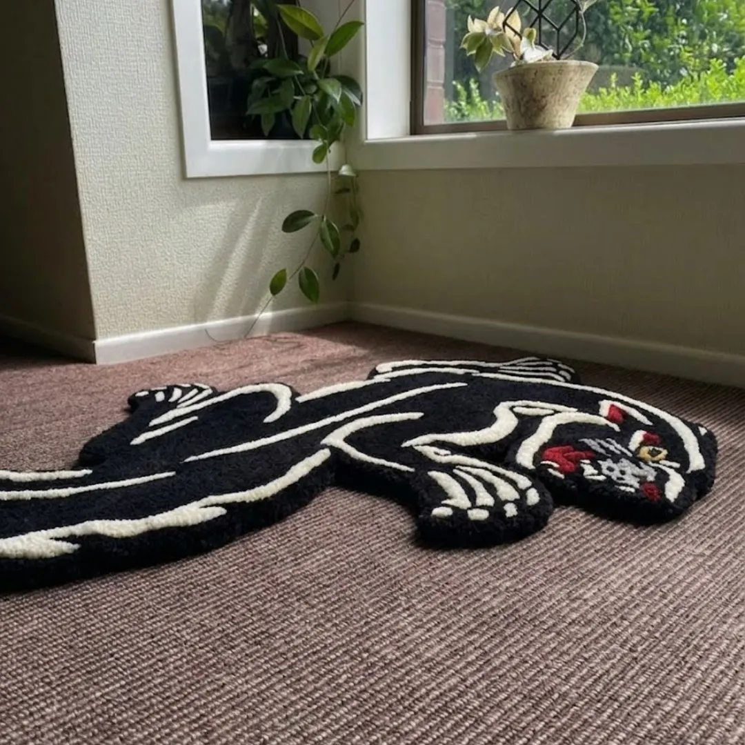 shadow prowl panther shaped area rug perspective detail An angled perspective shot of the Shadow Prowl panther rug, showcasing its unique animal-shaped silhouette and the high-contrast black and white fiber detailing.