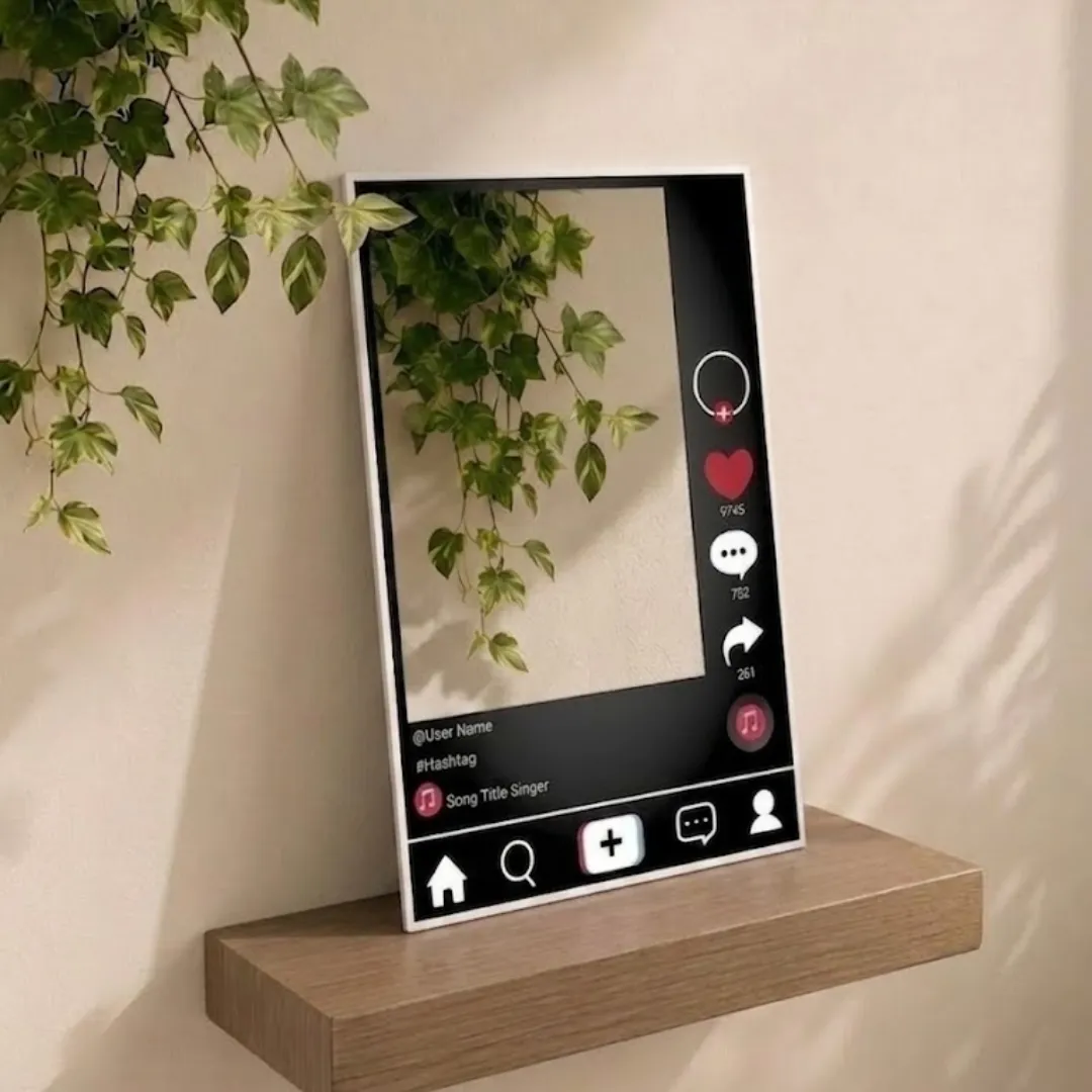 social frame tiktok style mirror angled view Angled view of the Social Frame mirror, mimicking a social media post interface, positioned on a wooden shelf against a beige wall with hanging ivy foliage.