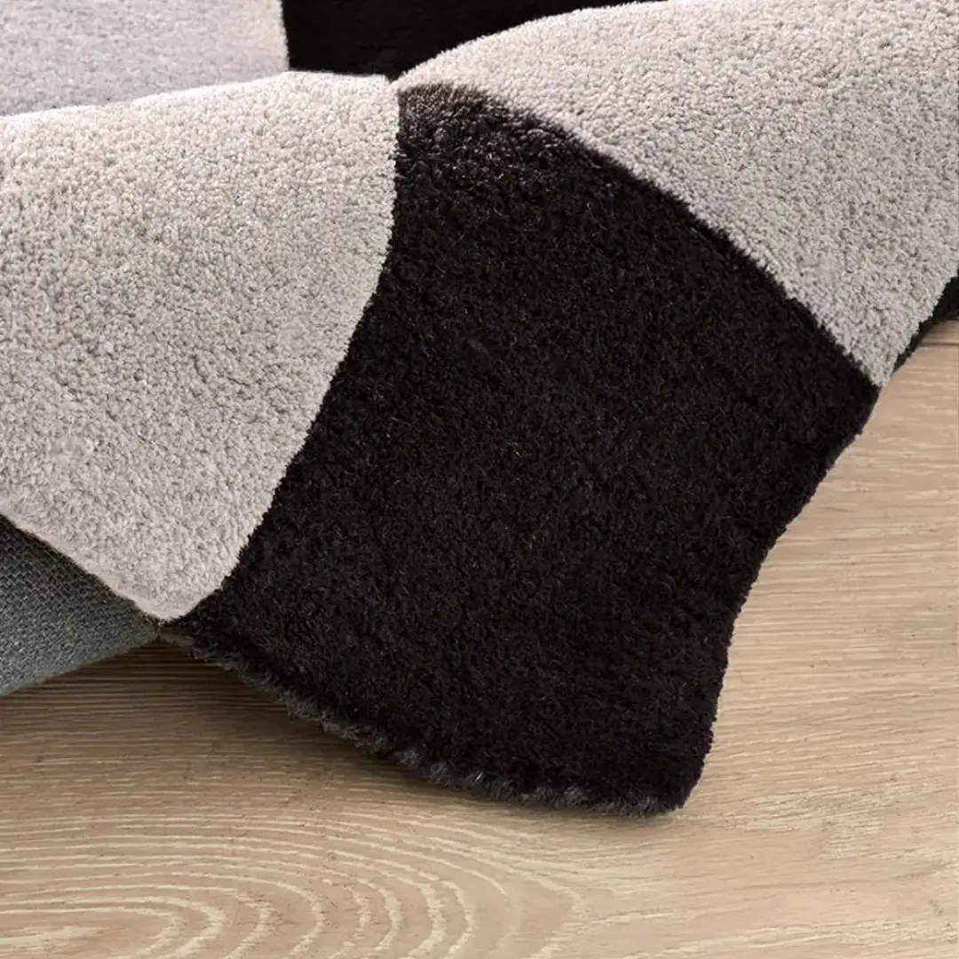 Checkerboard wool area rug laid on hardwood flooring