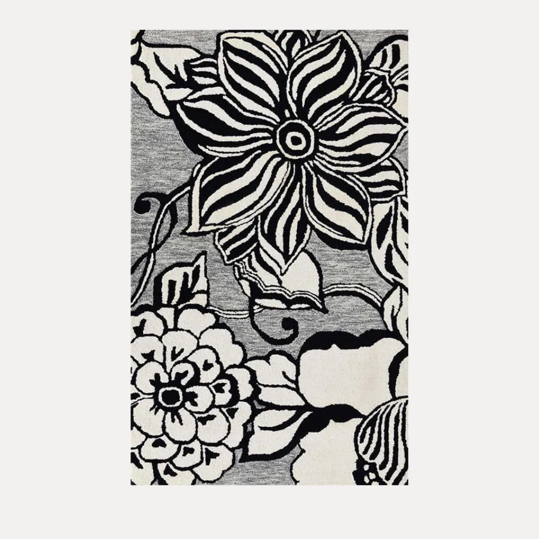 Black and white floral rug with oversized blooms on gray base