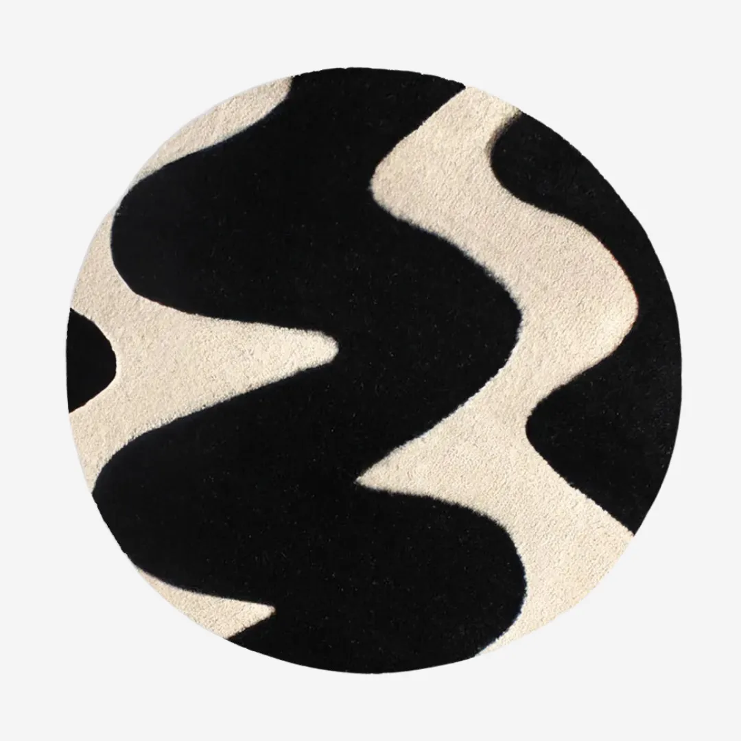 Round black and white wavy rug on hardwood floor