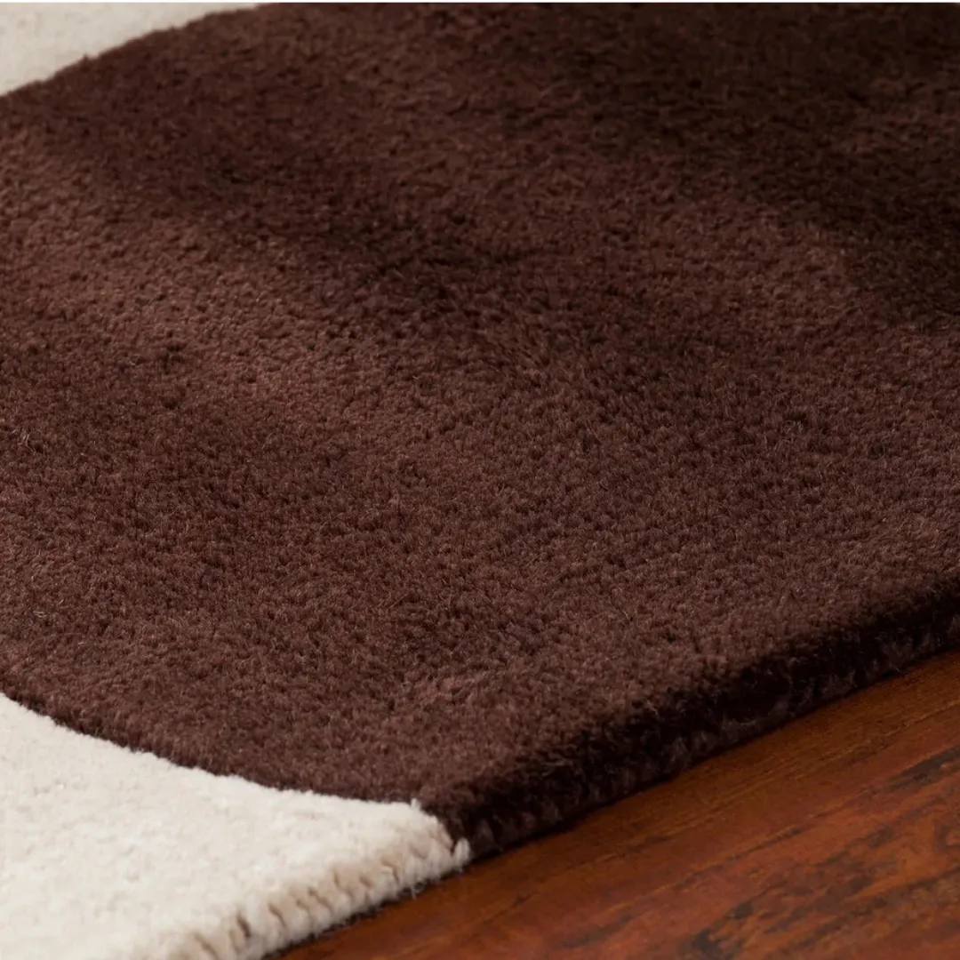 Circular blue and grey dots on hand-tufted chocolate brown wool