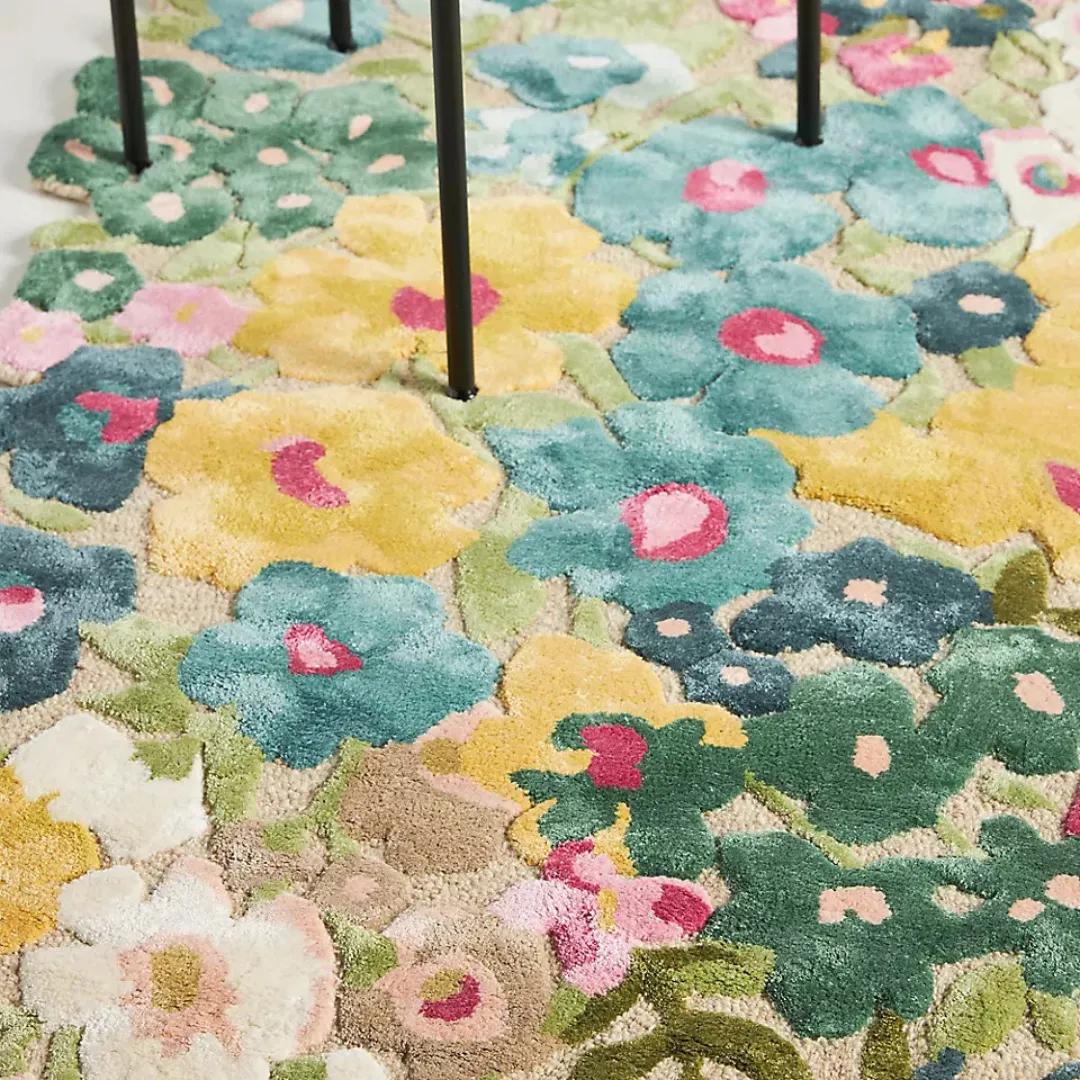 Whimsical floral wool rug with scalloped edges in sunlit bedroom