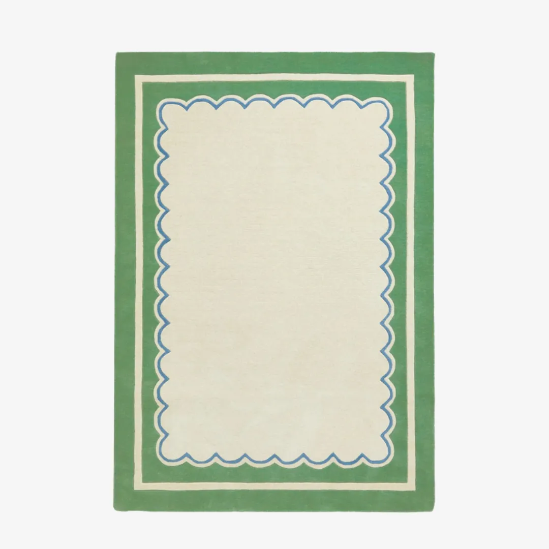 Green scallop border hand tufted rug with cream center and blue trim