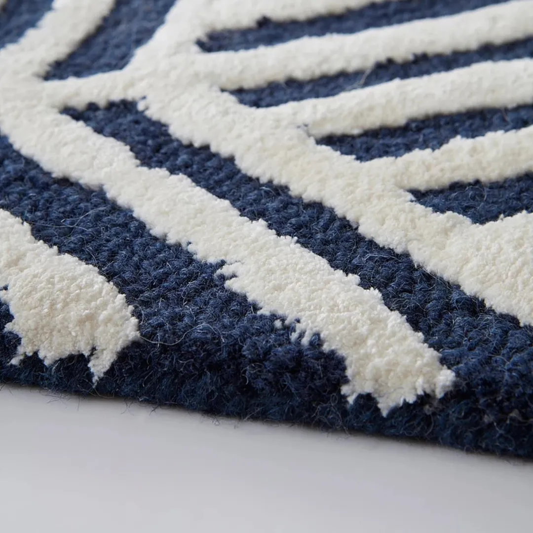 Detailed corner of geometric blue area rug on wooden floor