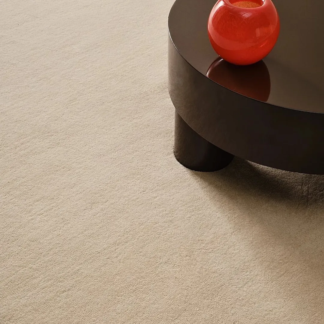 Soft wool beige rug on wooden floor