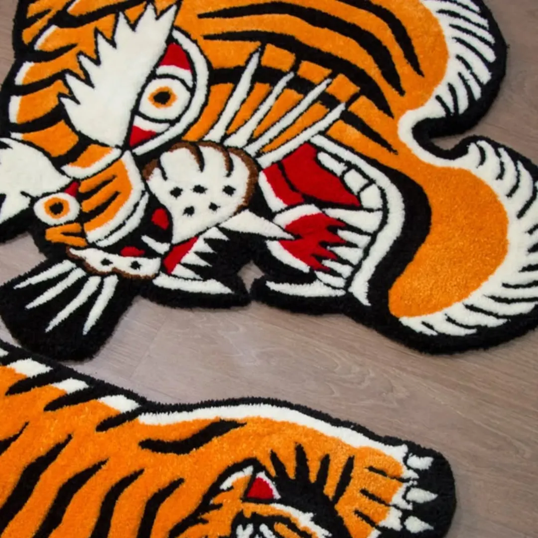 Custom-shaped tiger rug with thick tufted texture in orange, white, red, and black.