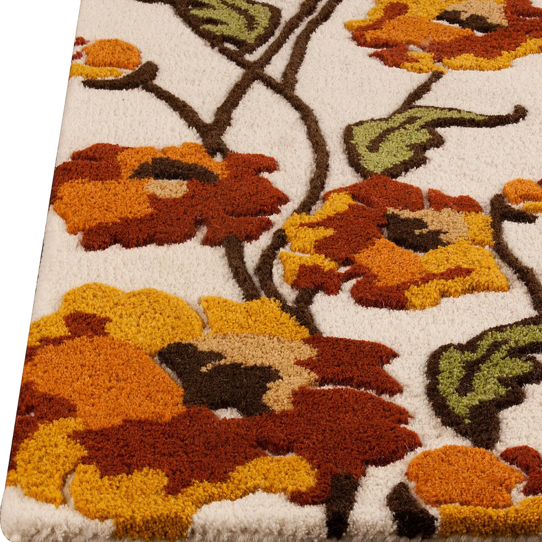 Floral rug in orange, yellow, and green on cream background