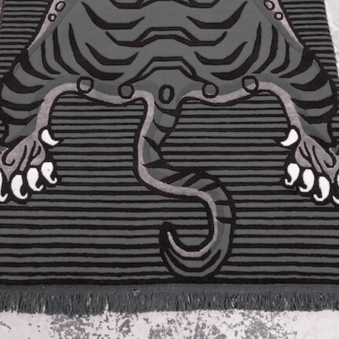 Black and grey tiger rug with striped pattern and fierce stylized tiger face, inspired by Tibetan rugs