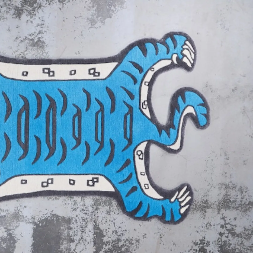 Blue tiger-shaped rug styled in a modern creative space