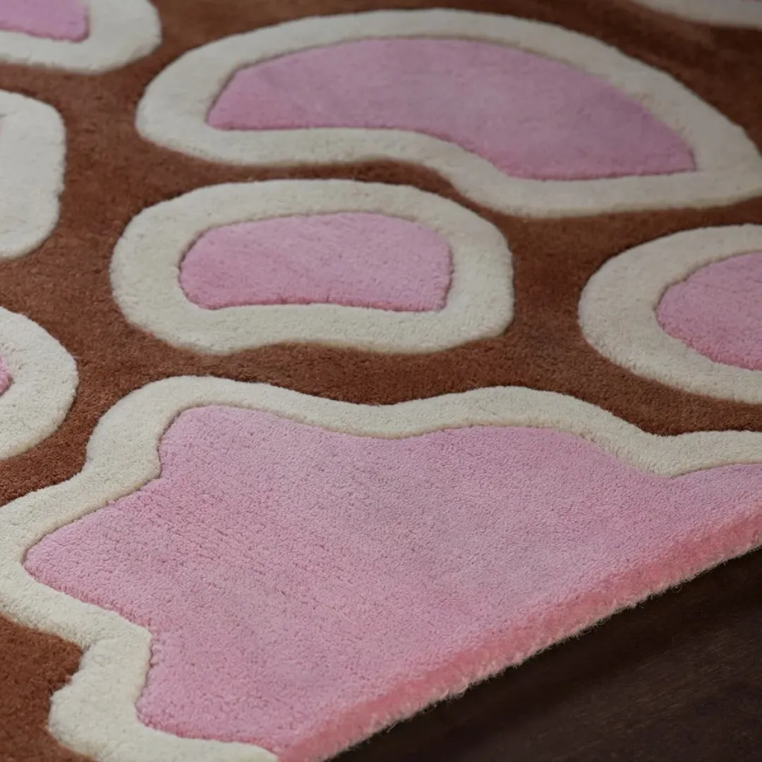 Handmade wool rug featuring a bold floral pattern in warm colors