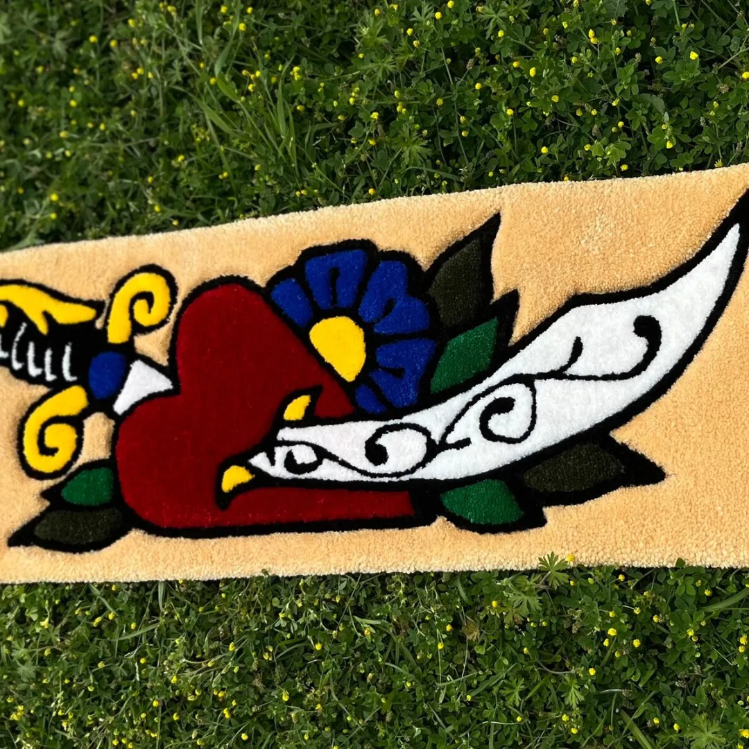Tufted rug with a red heart, dagger, flower, and banner in classic inked flash art style