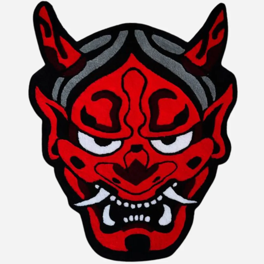 Hand tufted red Oni mask rug with black horns, white fangs, and grey accents on a wood floor