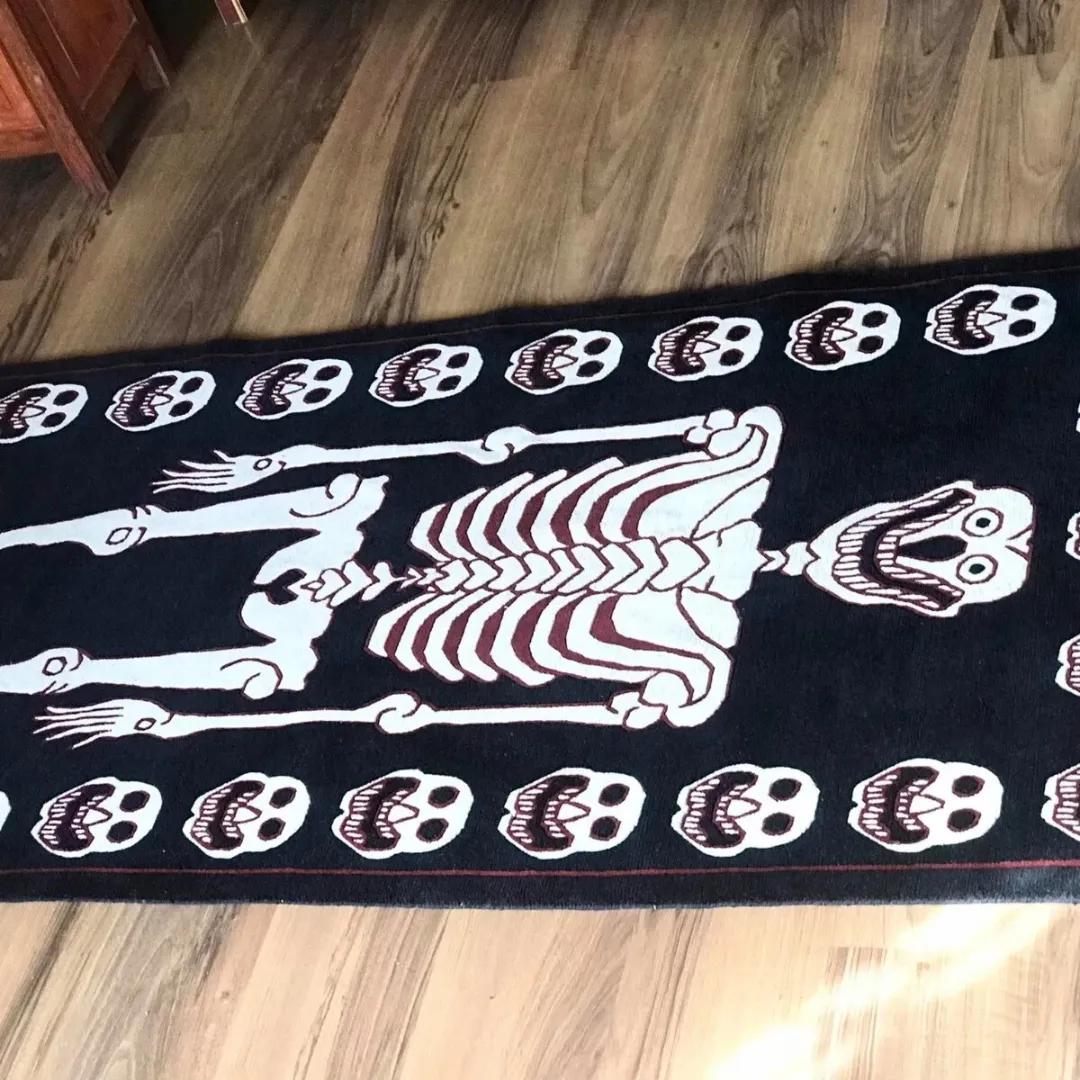 Skeleton rug styled in a dark-themed creative or Halloween-inspired room