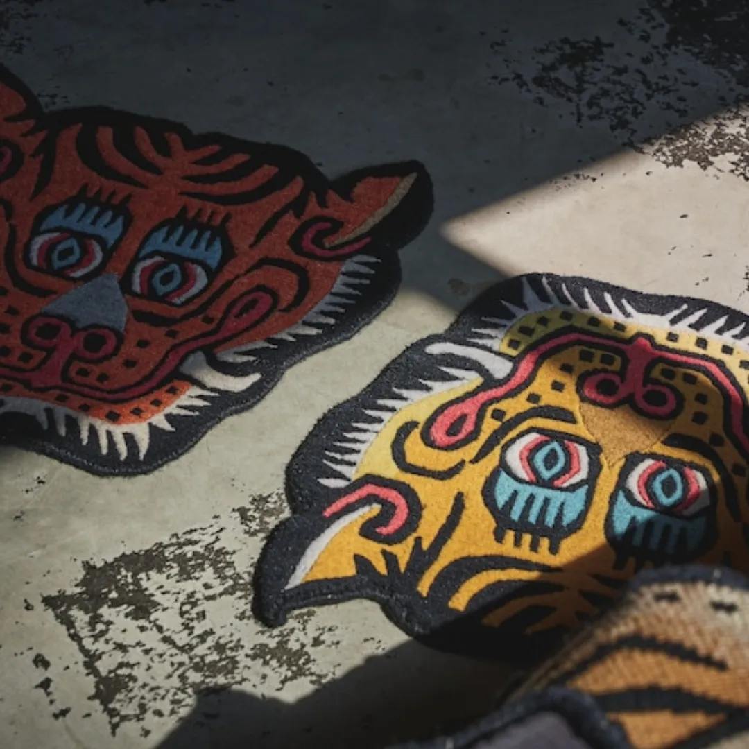 Tiger mask-style rug with strong outlines and vibrant details, made by Tibetan artisans.